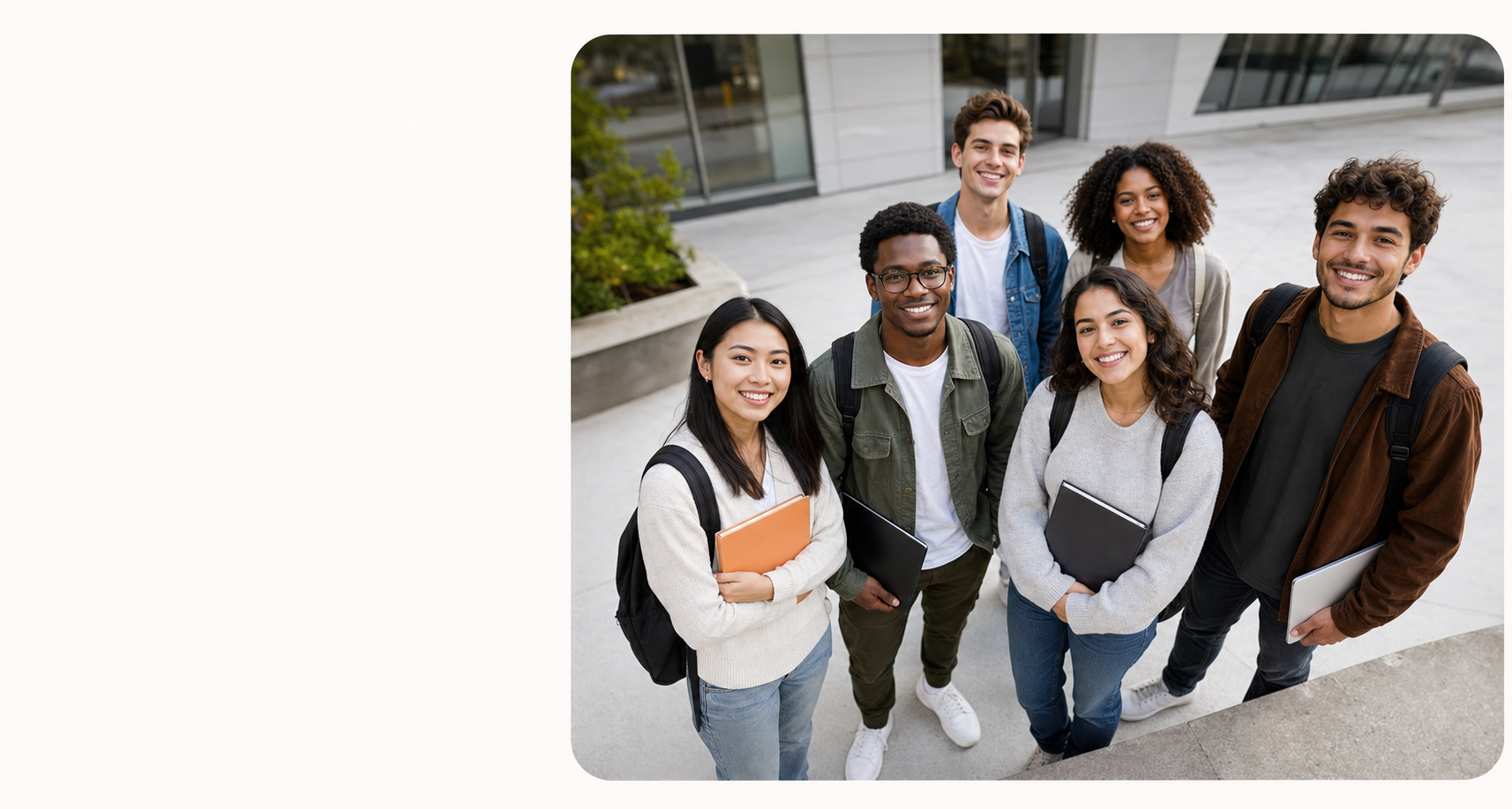 A diverse group of smiling university students standing outside a campus building and looking up at the camera